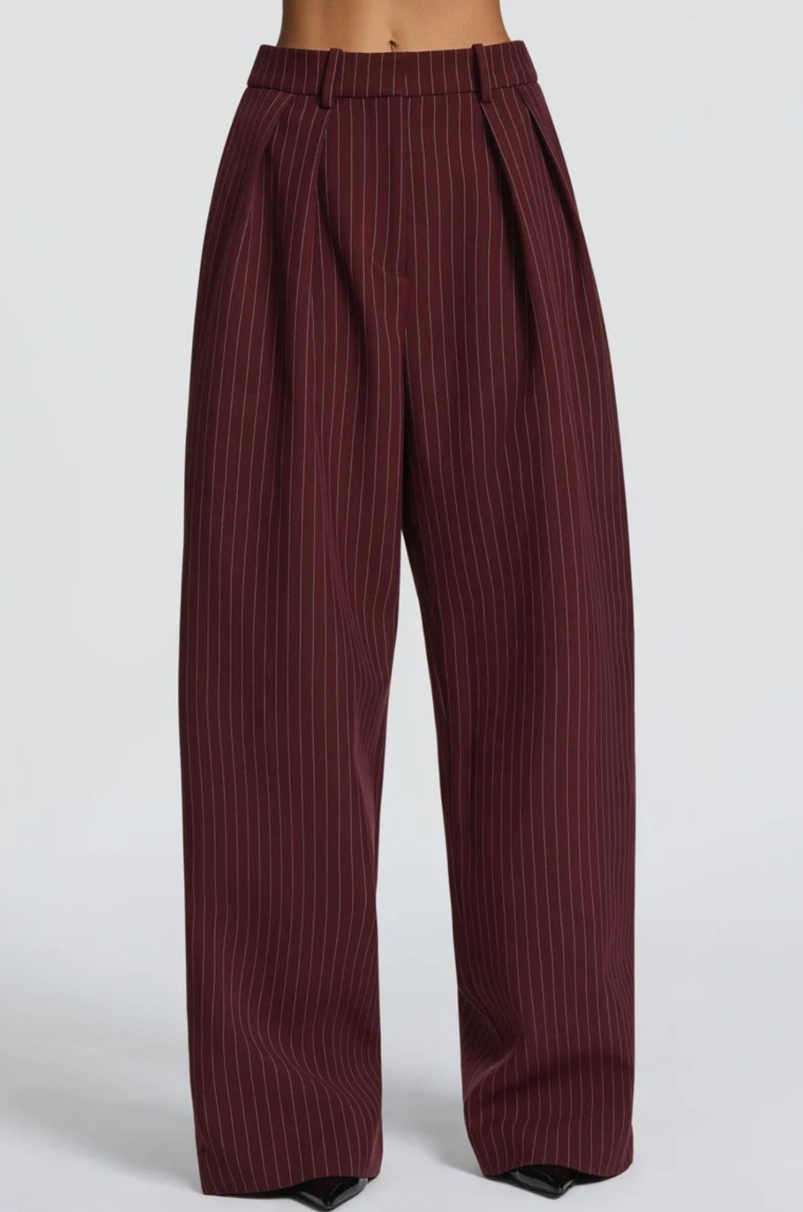 L'essenza del Tailleur Ilary contemporaneo gessato. Questo set coordinato combina un blazer monopetto strutturato a spalla definita con pantaloni palazzo a gamba larga caduta fluida. Il motivo gessato sottile regala una silhouette slanciata ed elegante