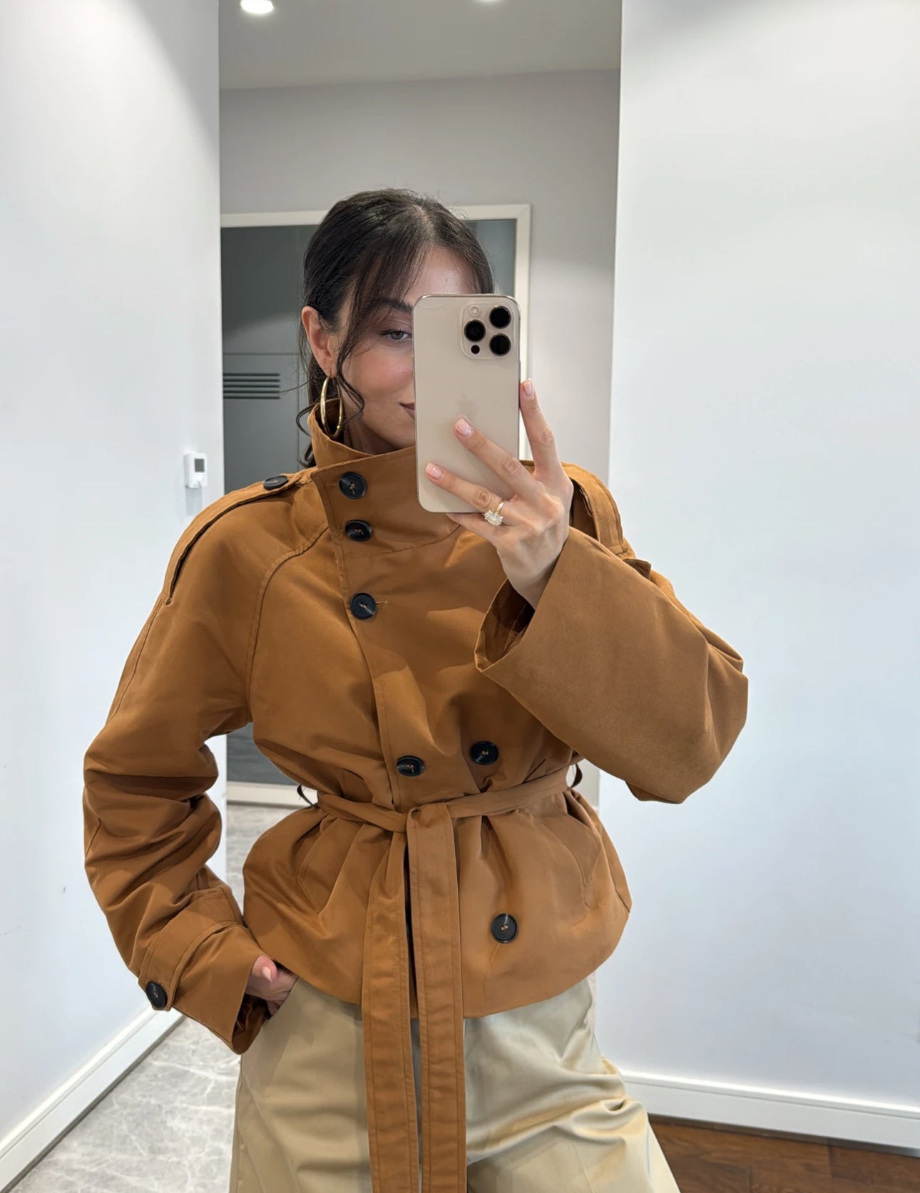 Trench NEW YORK Elegante trench corto con cintura regolabile e bottoni a contrasto. Design moderno e versatile, perfetto per look casual o raffinati.