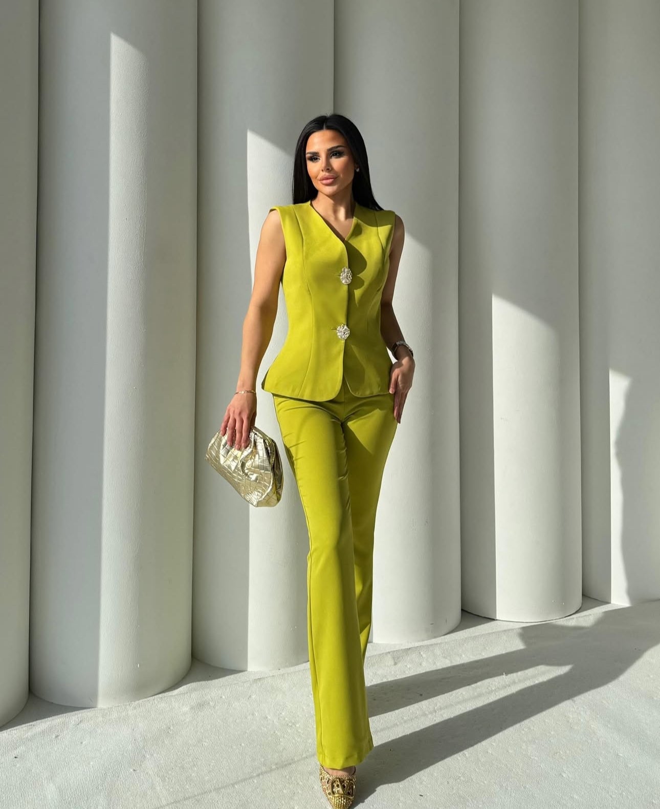 Set cord PERLA elegante composto da un gilet smanicato e un paio di pantaloni a gamba larga Il gilet presenta due bottoni decorativi centrali dal design gioiello. I pantaloni sono a vita alta, con una vestibilità morbida e fluida