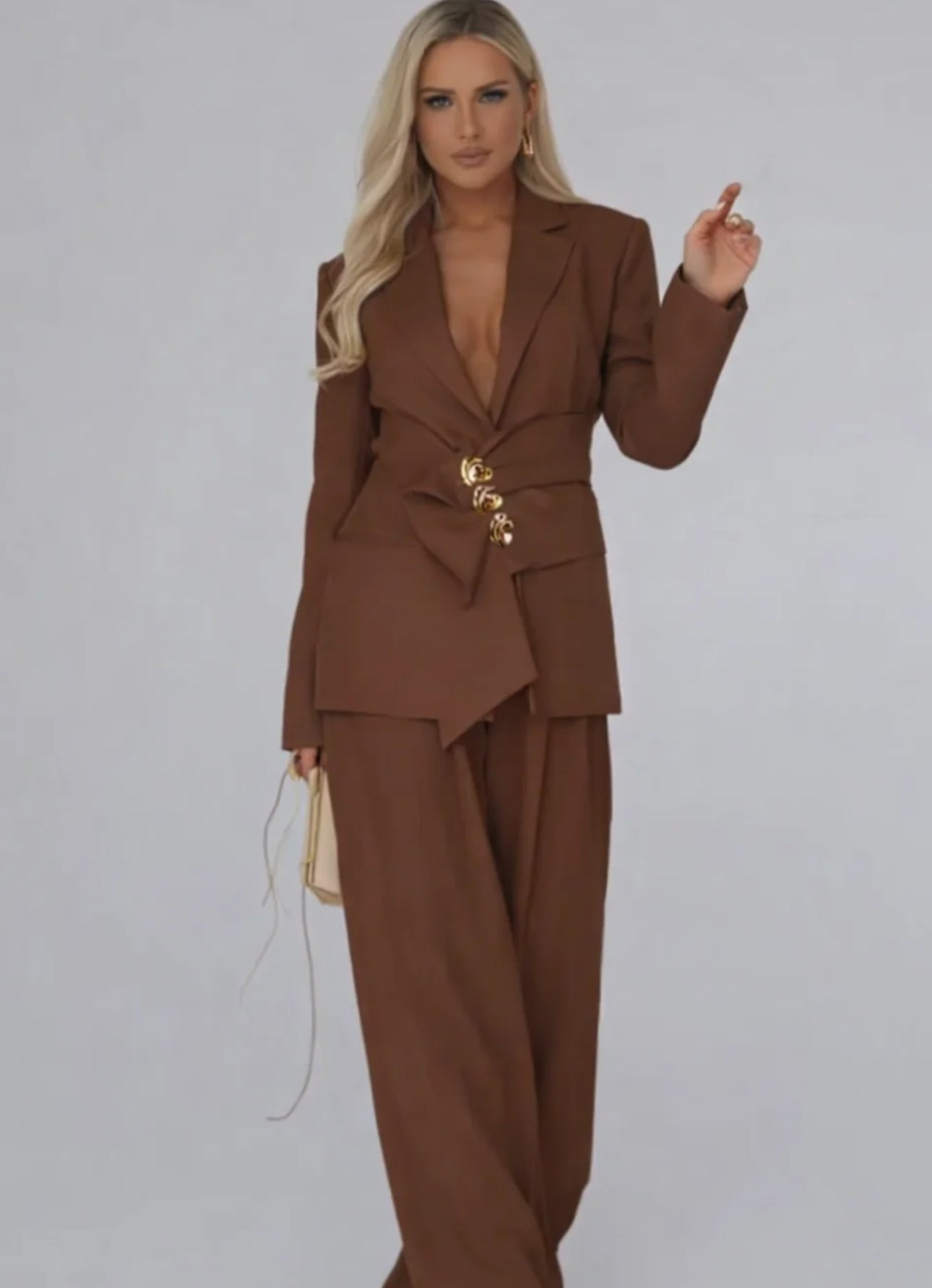 Tailleur Letizia composto da blazer strutturato con chiusura asimmetrica bottoni gioiello e pantaloni palazzo fluidi. Linee raffinate che valorizzano la silhouette, perfetto per occasioni chic o outfit da giorno sofisticati.
