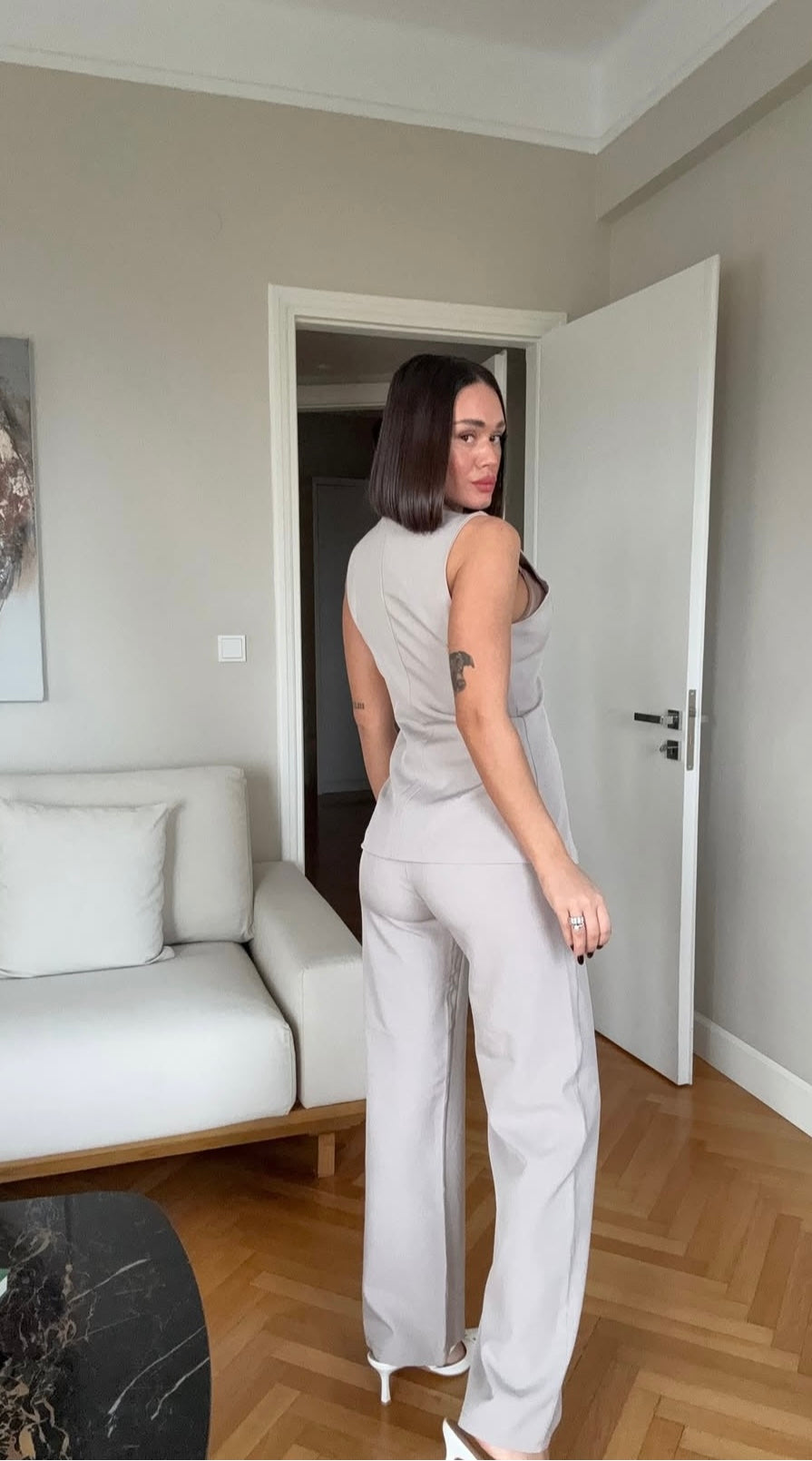 Tailleur ESTER elegante composto da un gilet smanicato e un paio di pantaloni a gamba larga Il gilet presenta due bottoni decorativi centrali dal design gioiello. I pantaloni sono a vita alta, con una vestibilità morbida e fluida