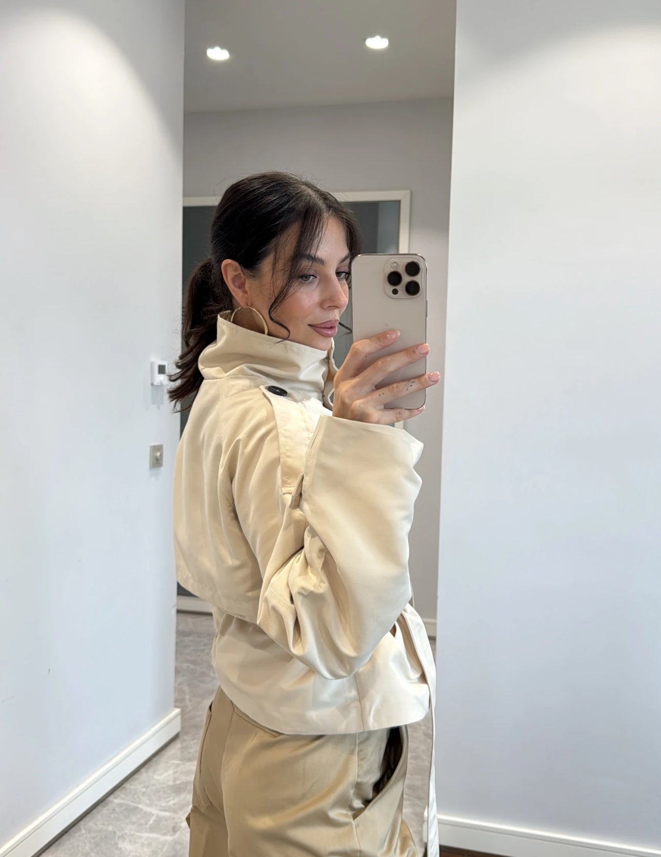 Trench NEW YORK Elegante trench corto con cintura regolabile e bottoni a contrasto. Design moderno e versatile, perfetto per look casual o raffinati.