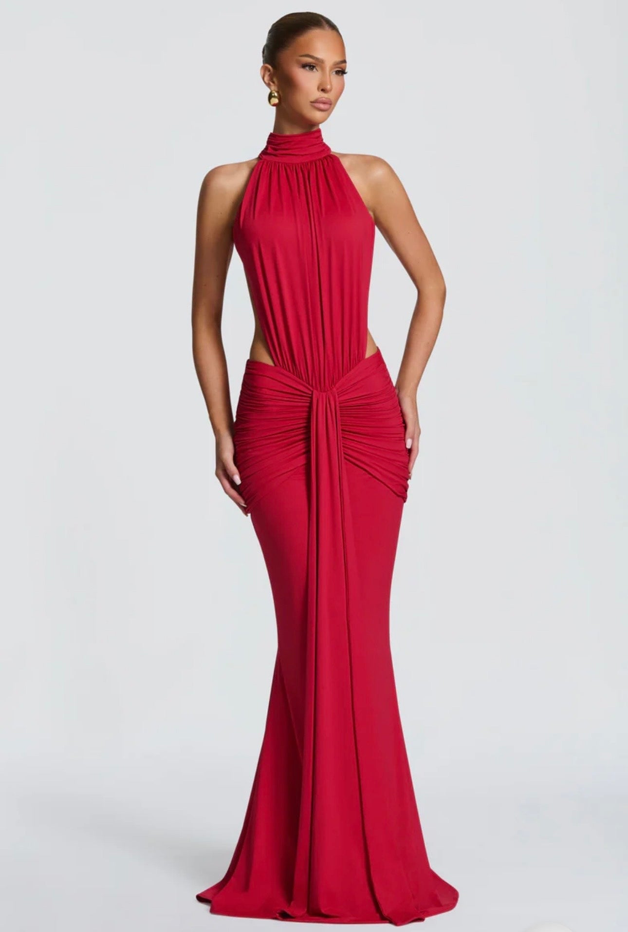 Abito Sofia Caratterizzato da una silhouette a sirena che valorizza le forme, questo modello unisce un sofisticato collo alto a un audace gioco di drappeggi e intagli cut-out sui fianchi.