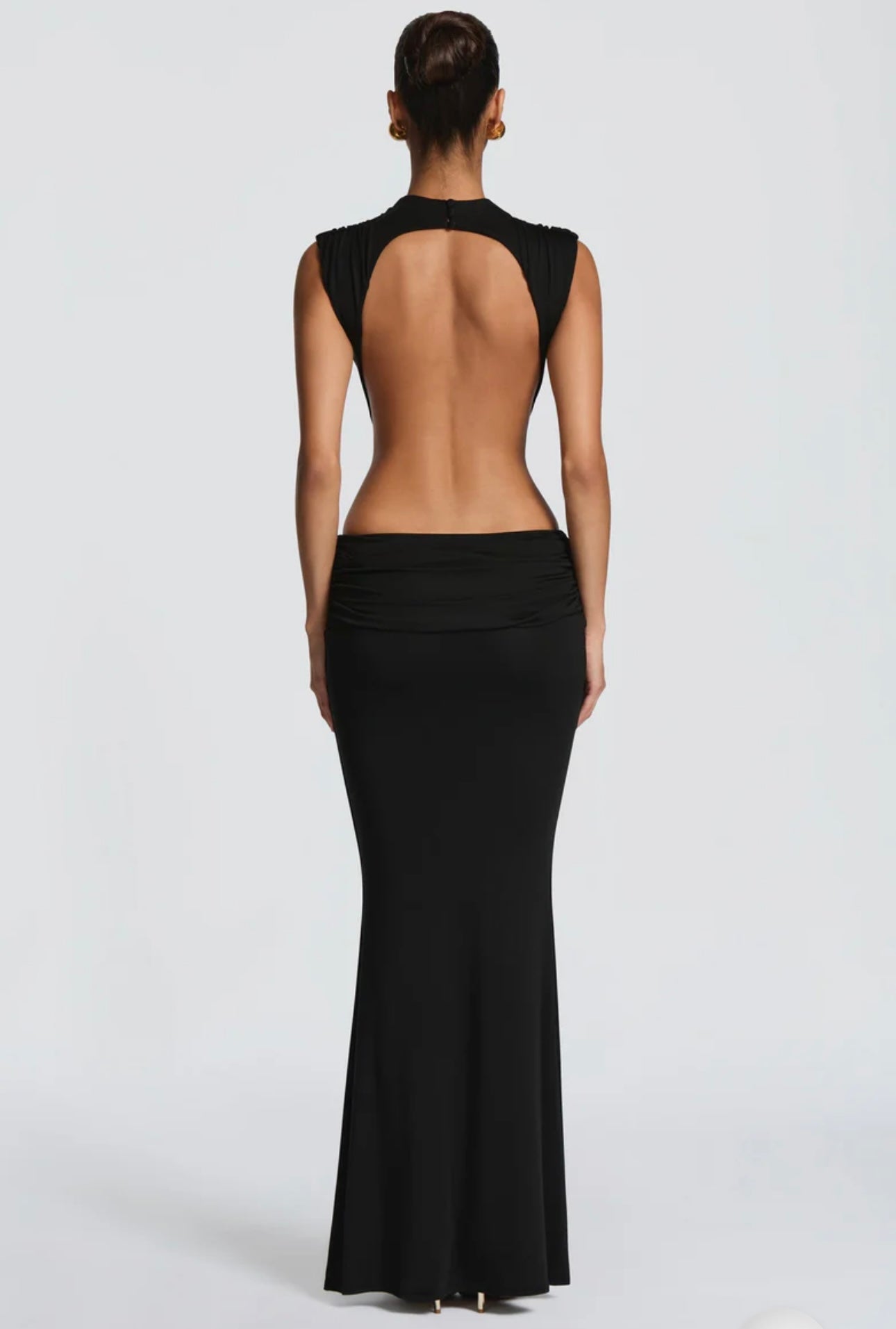 Abito Sahara maxi aderente in elegante rosa terracotta con design cut-out laterale che scolpisce la silhouette. Il collo alto crea un raffinato contrasto con le ampie aperture sui fianchi e la schiena scoperta, per un effetto sensuale ma sofisticato.