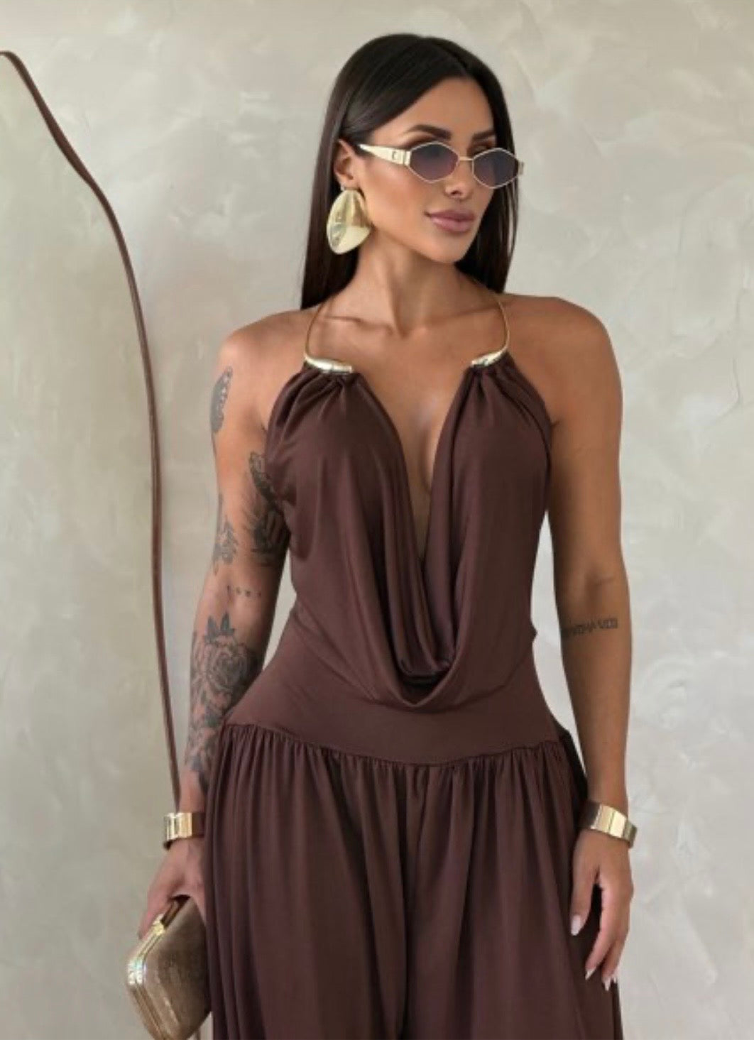 Jumpsuite Gioia Un'eleganza senza tempo racchiusa in una silhouette fluida e sensuale. La Tuta Drappeggiata è pensata per la donna che sa come catturare ogni sguardo senza sforzo.