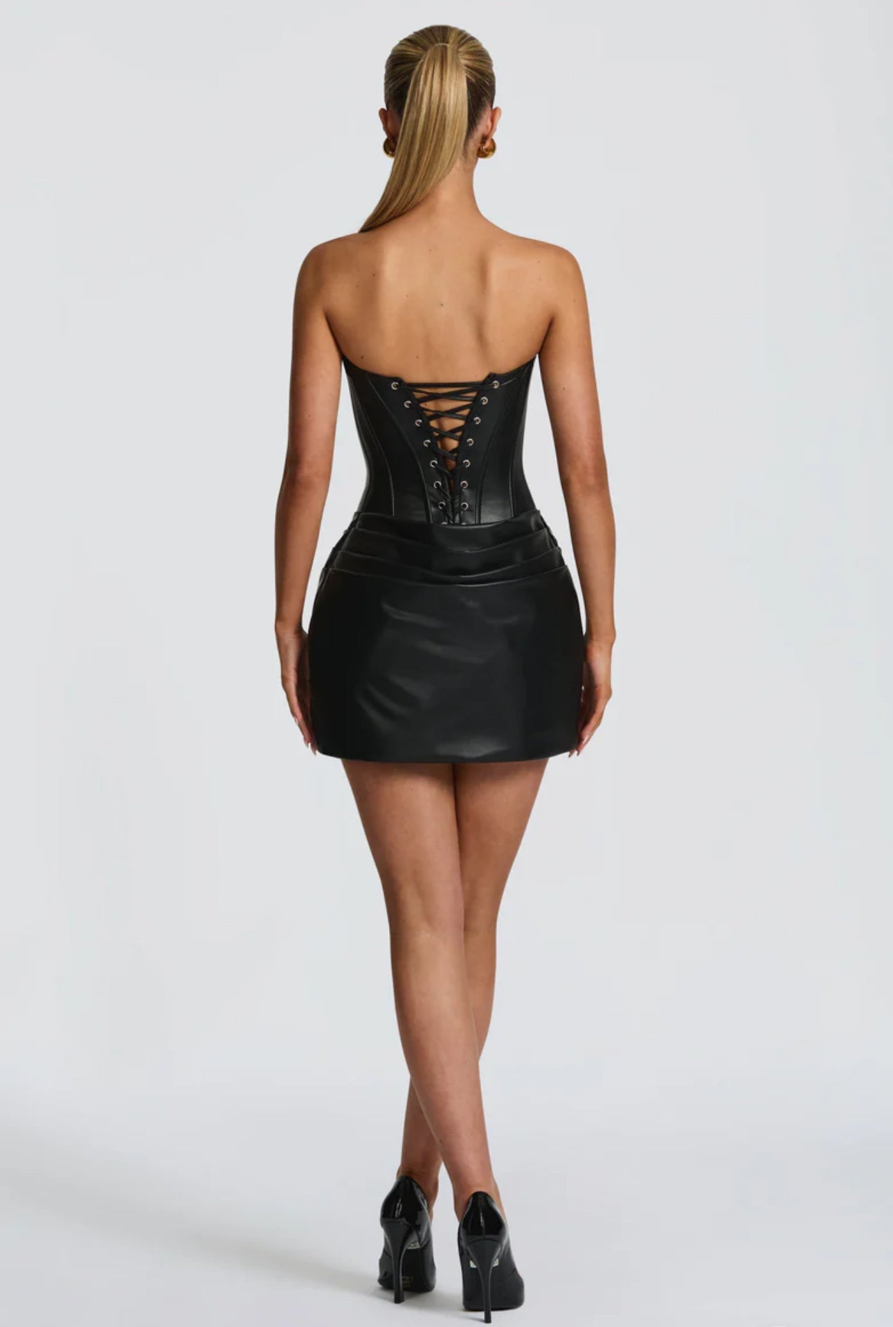 Abito corsetto in ecopelle “Valeria” Seduzione e carattere in un unico capo. Questo mini abito in ecopelle esalta la silhouette grazie al corsetto strutturato e alla chiusura con lacci sul retro. Il drappeggio delicato sulla gonna aggiunge eleganza