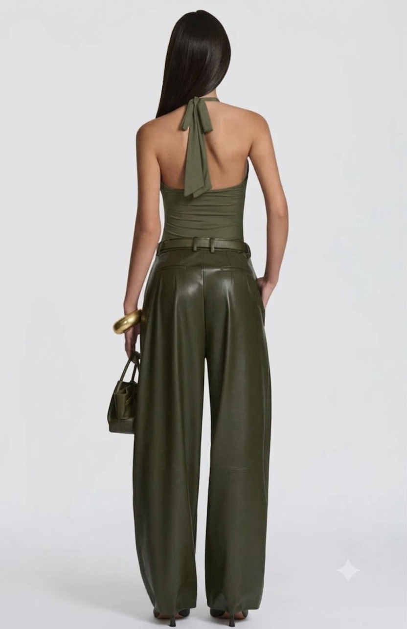 Pantalone Palazzo in Faux Leather Caratterizzato da una gamba ampia palazzo e doppie pinces frontali, dona un movimento sofisticato a ogni passo. La cintura sottile coordinata con fibbia metallica dorata definisce il punto vita.