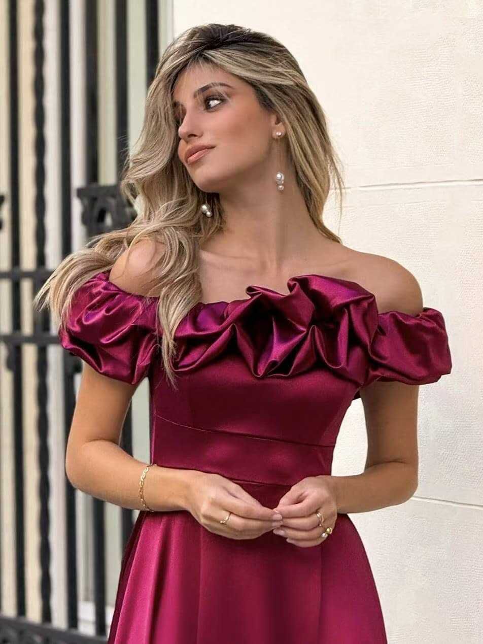 Abito MARYA Elegante abito off-shoulder con corpino arricciato a balze e ampia gonna con spacco laterale.