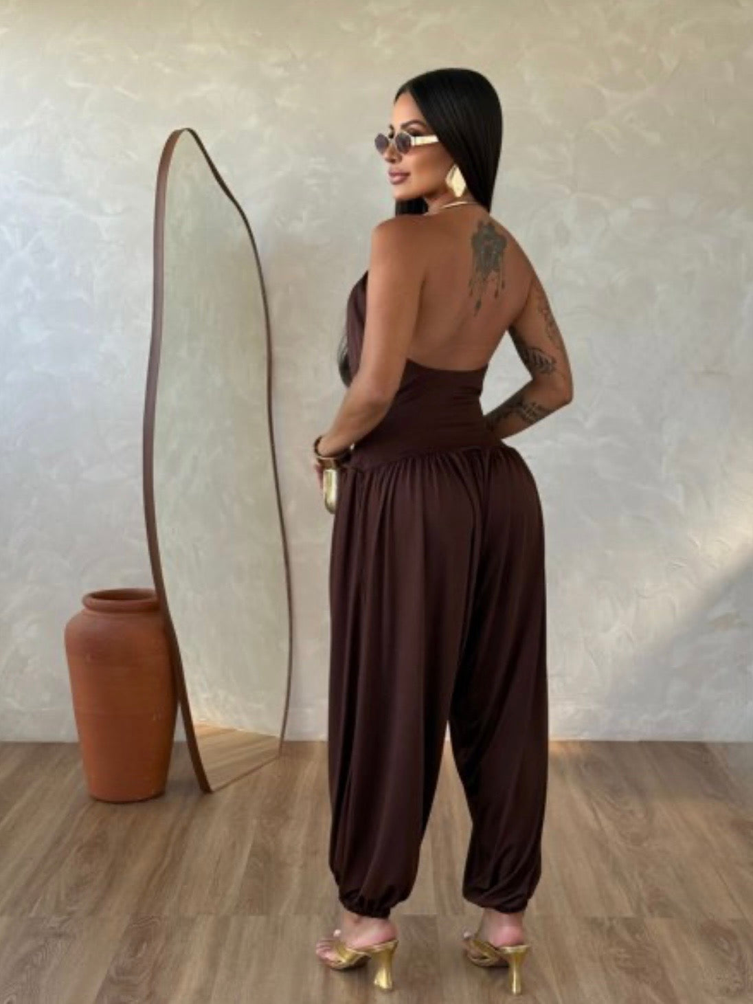 Jumpsuite Gioia Un'eleganza senza tempo racchiusa in una silhouette fluida e sensuale. La Tuta Drappeggiata è pensata per la donna che sa come catturare ogni sguardo senza sforzo.