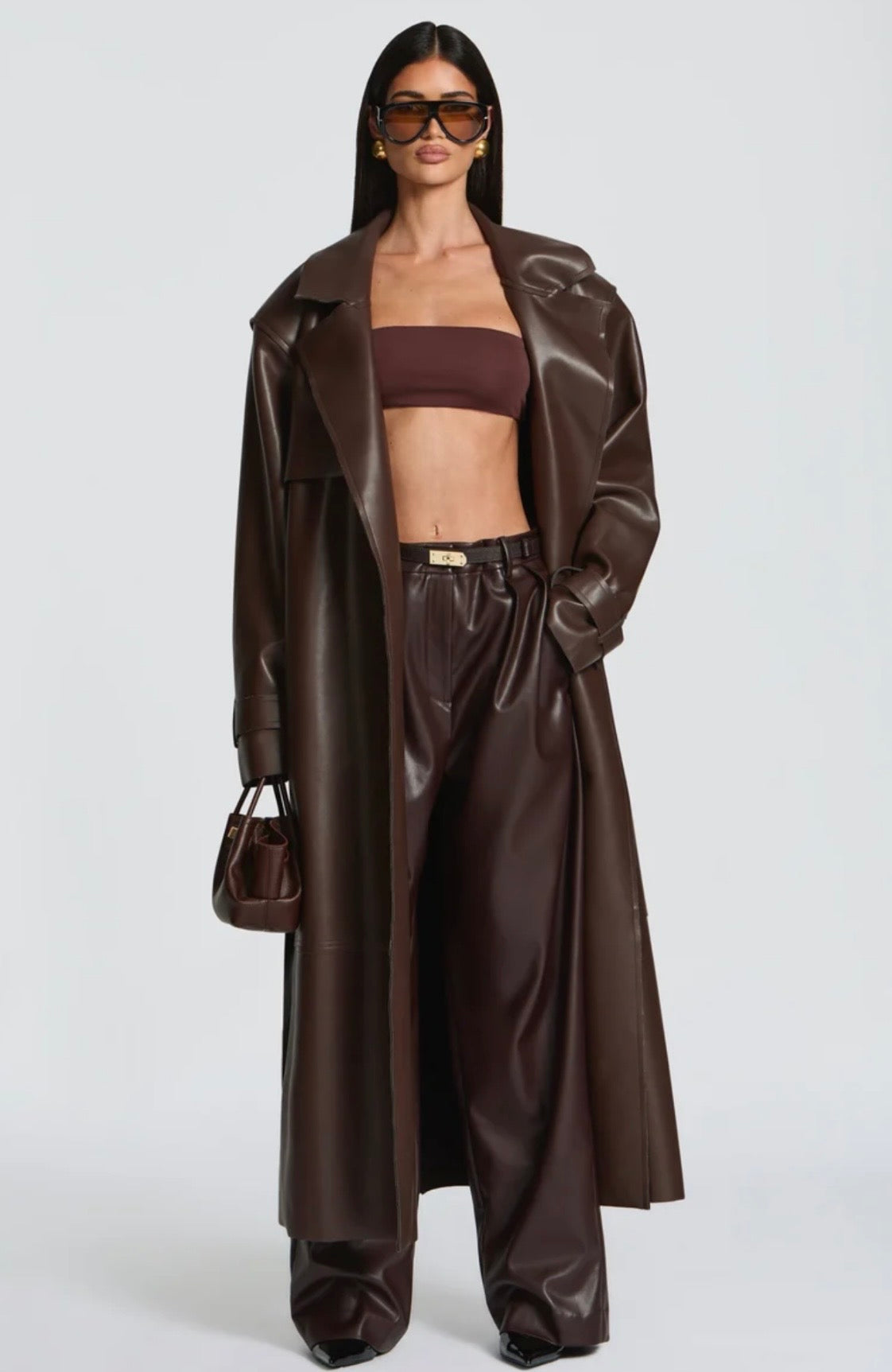Trench Coat Maxi in Eco pelle Caratterizzato da un'ampia mantellina (gun flap), spalline strutturate, revers generosi e una cintura coordinata da annodare in vita, regala una silhouette definita e d'impatto.
