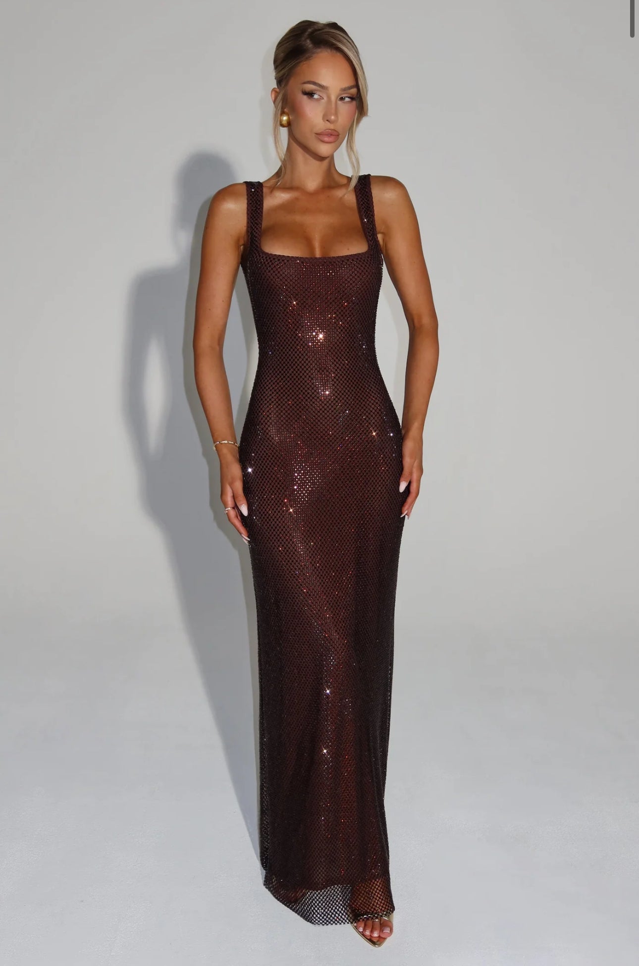 Abito LOLA Sensuale ed elegante, questo abito maxi scintillante avvolge la silhouette con una vestibilità morbida . Il tessuto luminoso cattura la luce ad ogni movimento, mentre lo scollo squadrato e le spalline larghe donano un tocco moderno e raffinato.
