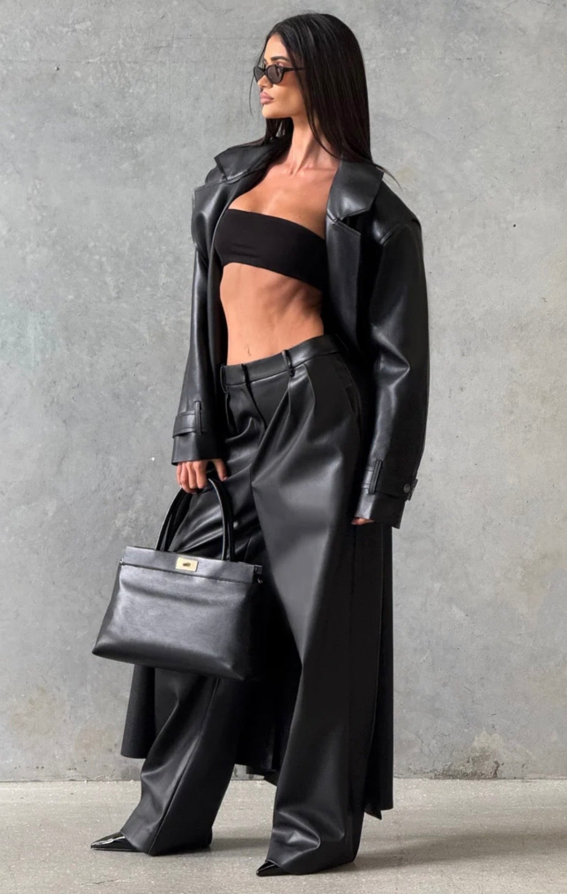 Trench Coat Maxi in Eco pelle Caratterizzato da un'ampia mantellina (gun flap), spalline strutturate, revers generosi e una cintura coordinata da annodare in vita, regala una silhouette definita e d'impatto.