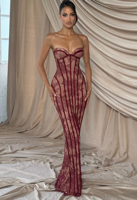 Abito Sophia lungo dal fascino sensuale ed elegante, realizzato in pizzo ricamato trasparente con base nude e dettagli neri a contrasto. Il corpetto strutturato stile bustier valorizza il décolleté.