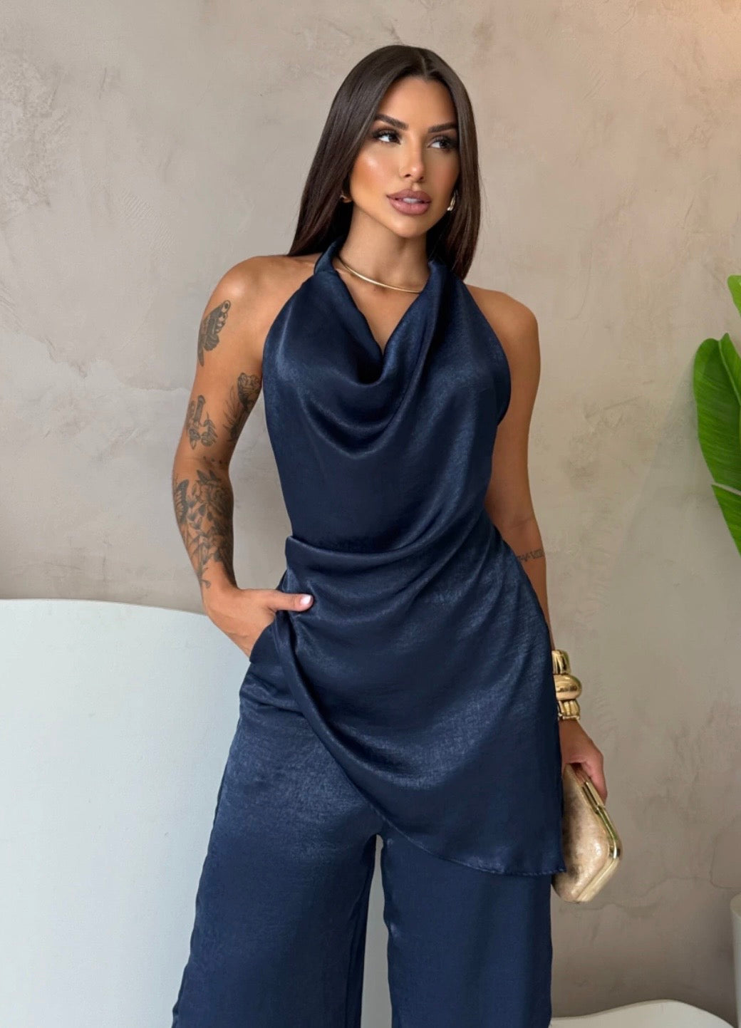 Coordinato Barbara Il set è composto di seta satinata da un top con scollo a cappuccio e schiena scoperta che valorizza la silhouette, abbinato a un pantalone a palazzo fluido che slancia la figura ad ogni passo.