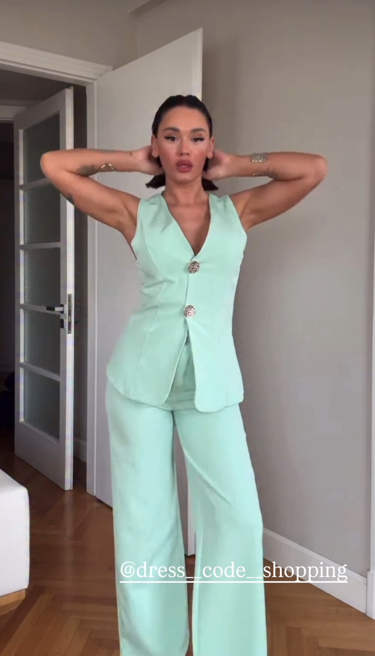 Tailleur ESTER elegante composto da un gilet smanicato e un paio di pantaloni a gamba larga  Il gilet presenta due bottoni decorativi centrali dal design gioiello. I pantaloni sono a vita alta, con una vestibilità morbida e fluida