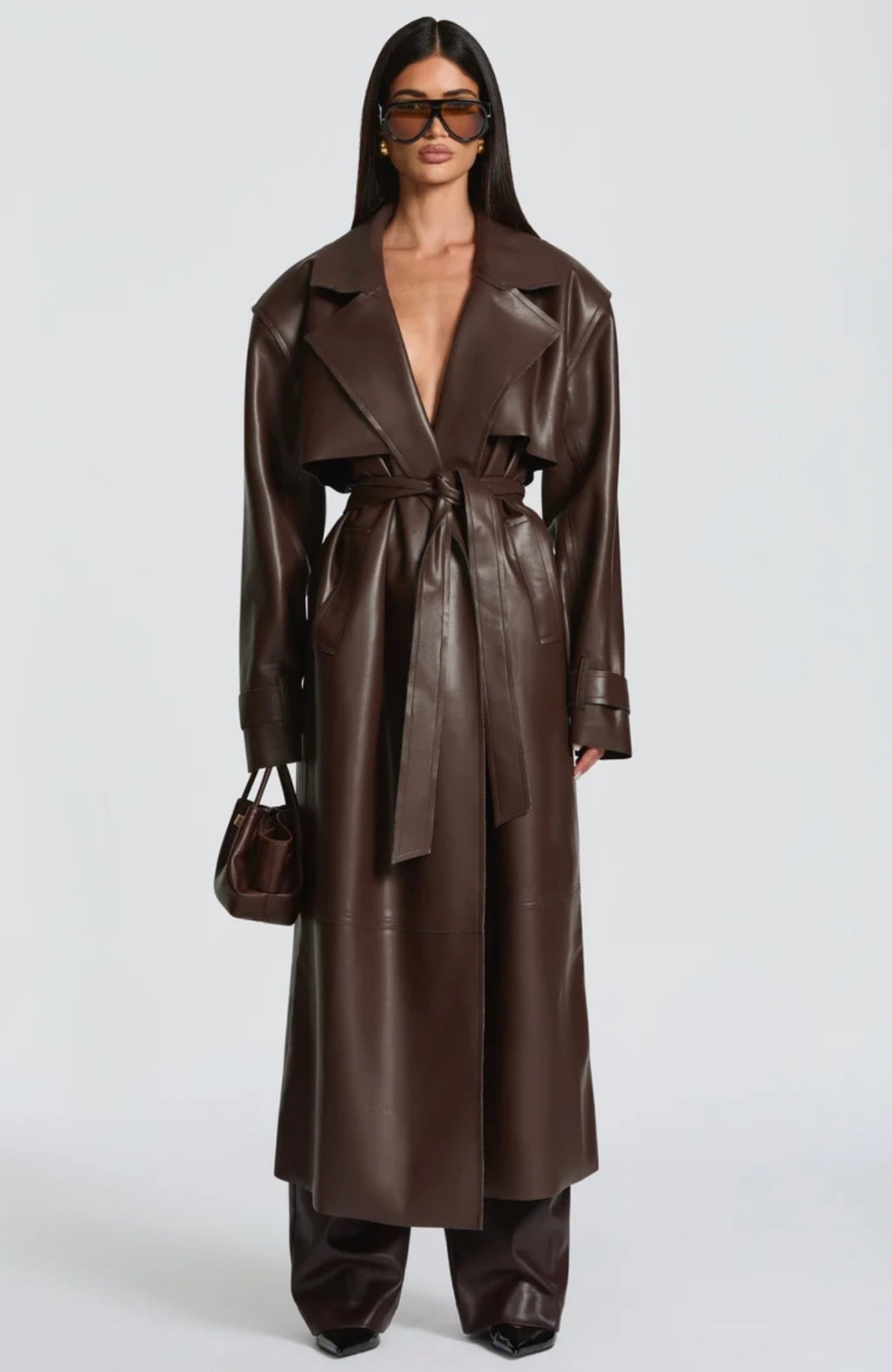 Trench Coat Maxi in Eco pelle Caratterizzato da un'ampia mantellina (gun flap), spalline strutturate, revers generosi e una cintura coordinata da annodare in vita, regala una silhouette definita e d'impatto.