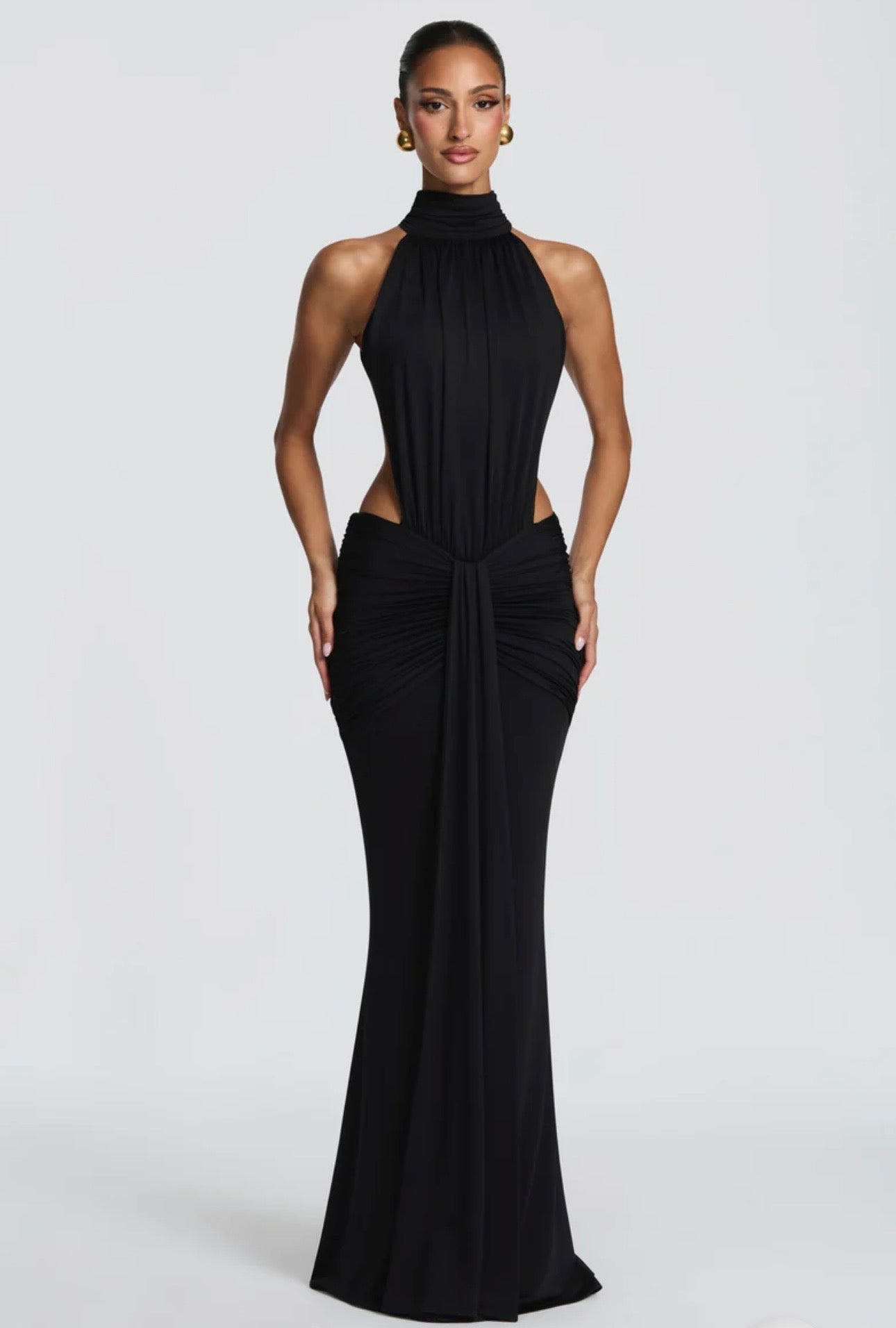 Abito Sofia Caratterizzato da una silhouette a sirena che valorizza le forme, questo modello unisce un sofisticato collo alto a un audace gioco di drappeggi e intagli cut-out sui fianchi.