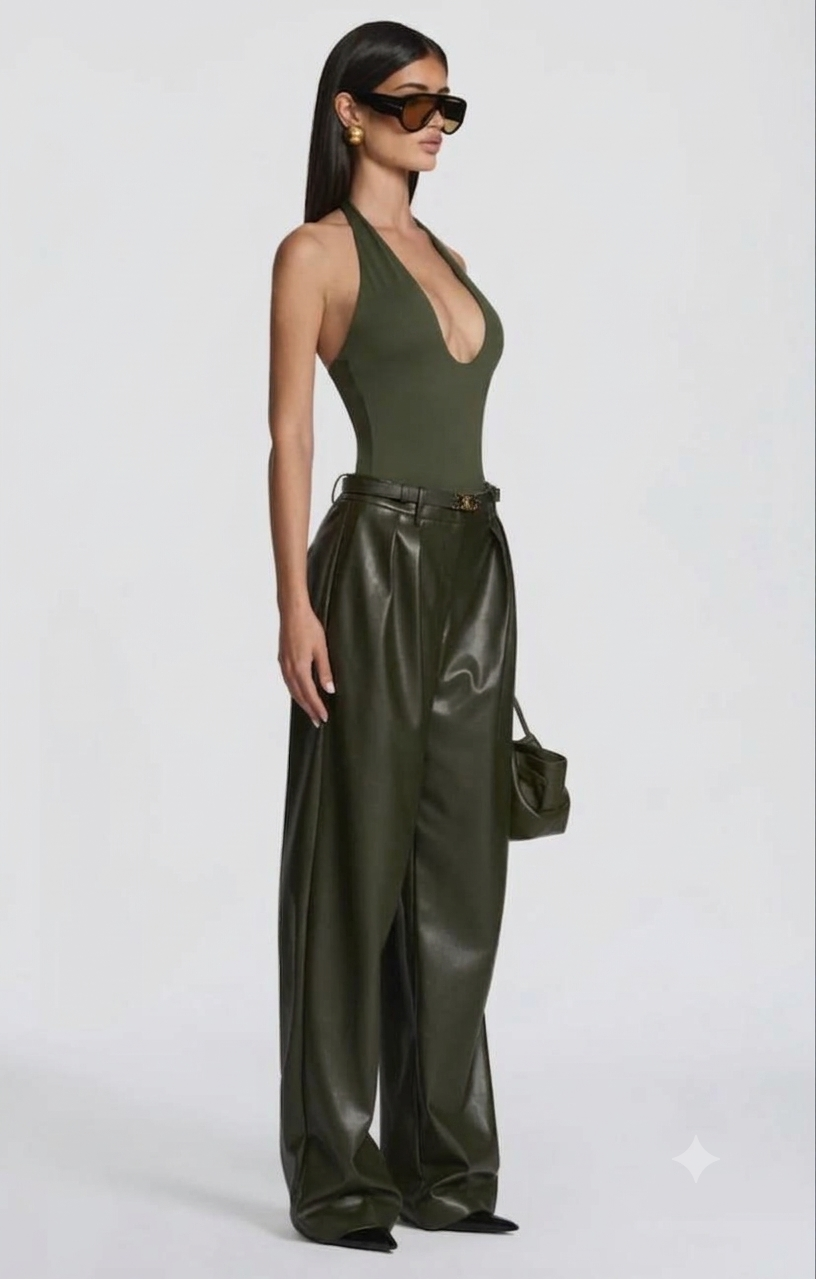 Pantalone Palazzo in Faux Leather Caratterizzato da una gamba ampia palazzo e doppie pinces frontali, dona un movimento sofisticato a ogni passo. La cintura sottile coordinata con fibbia metallica dorata definisce il punto vita.