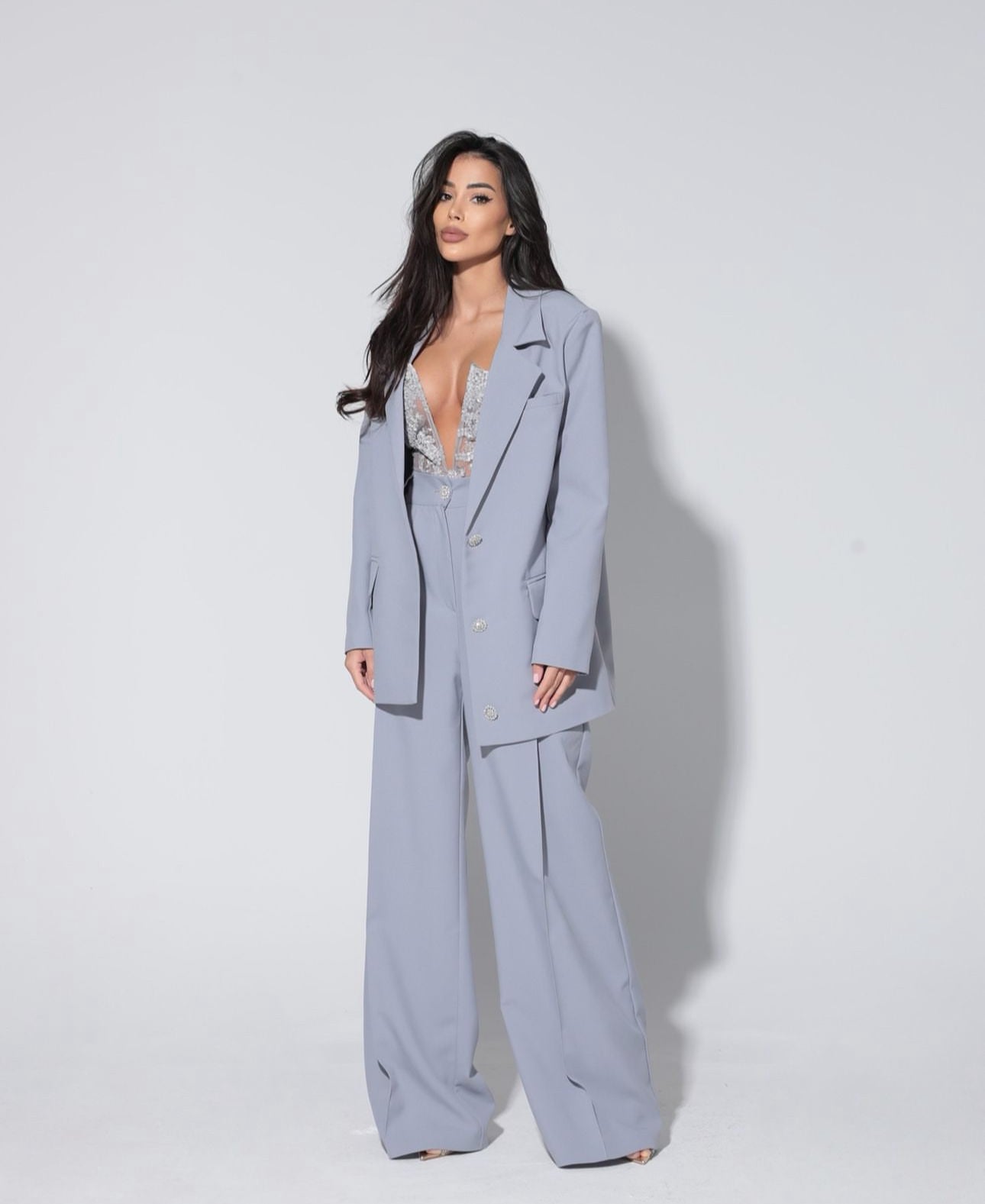 Tailleur Renata Questo completo è la scelta perfetta per distinguerti con stile: blazer dal taglio elegante, pantalone a gamba larga che slancia la figura e top in pizzo delicato che aggiunge un tocco sensuale e sofisticato.