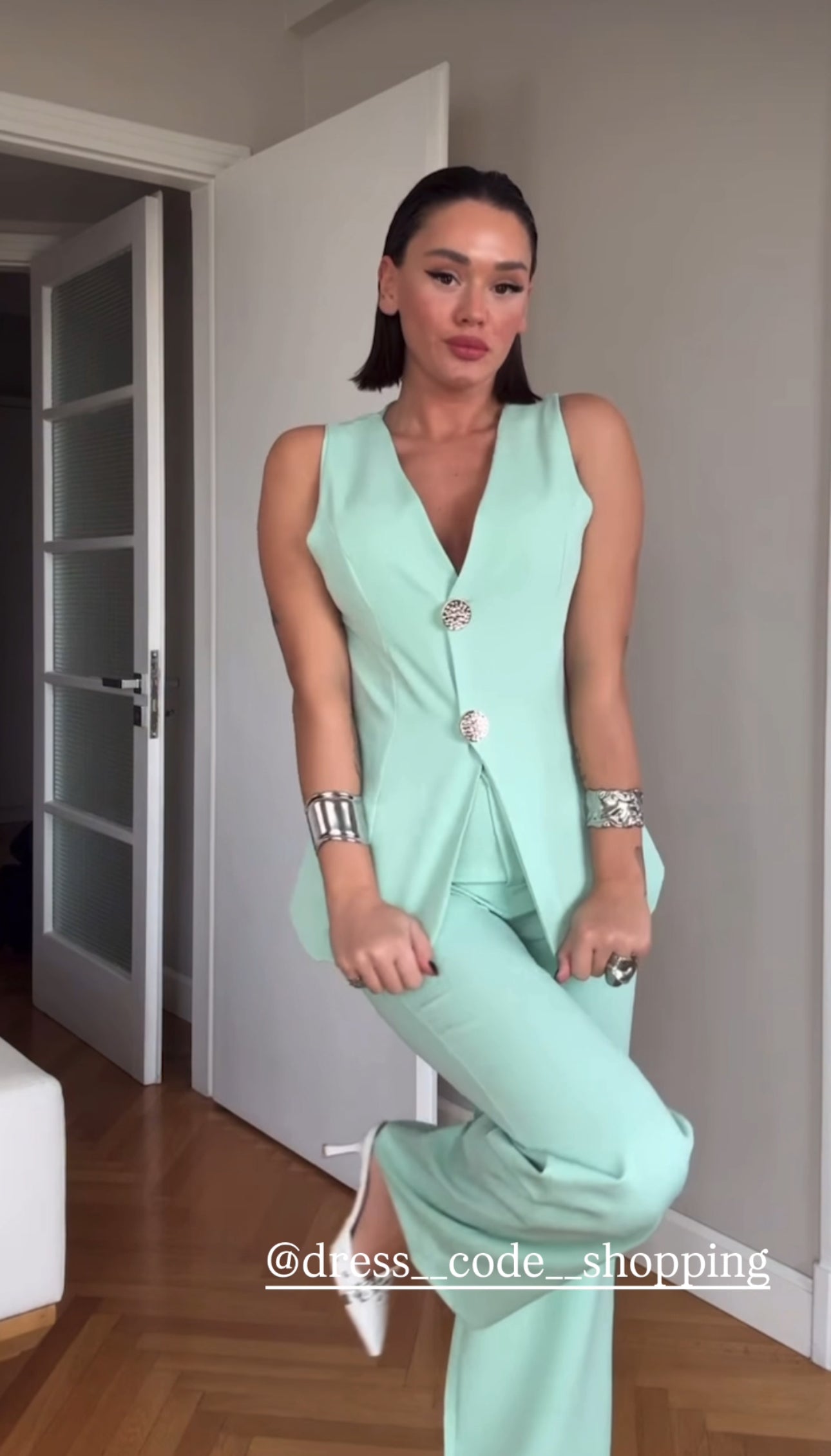 Tailleur ESTER elegante composto da un gilet smanicato e un paio di pantaloni a gamba larga  Il gilet presenta due bottoni decorativi centrali dal design gioiello. I pantaloni sono a vita alta, con una vestibilità morbida e fluida