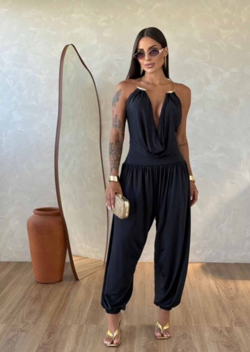 Jumpsuite Gioia Un'eleganza senza tempo racchiusa in una silhouette fluida e sensuale. La Tuta Drappeggiata è pensata per la donna che sa come catturare ogni sguardo senza sforzo.