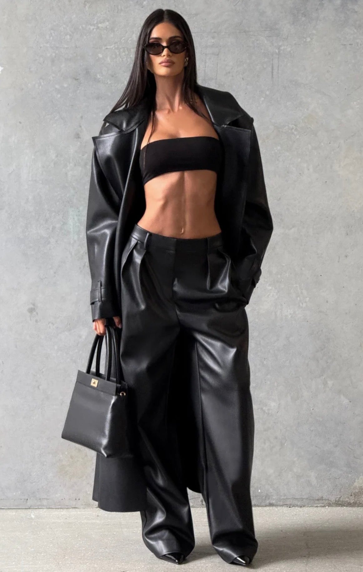 Trench Coat Maxi in Eco pelle Caratterizzato da un'ampia mantellina (gun flap), spalline strutturate, revers generosi e una cintura coordinata da annodare in vita, regala una silhouette definita e d'impatto.