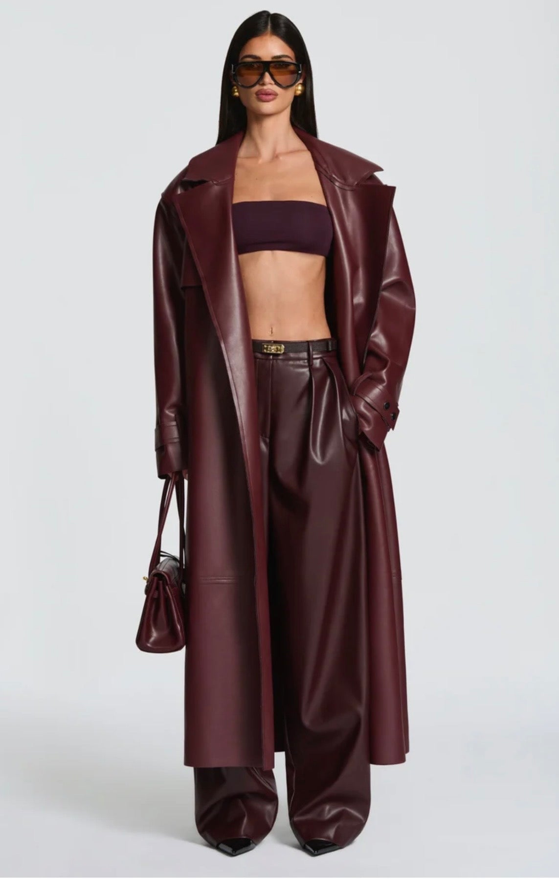 Trench Coat Maxi in Eco pelle Caratterizzato da un'ampia mantellina (gun flap), spalline strutturate, revers generosi e una cintura coordinata da annodare in vita, regala una silhouette definita e d'impatto.