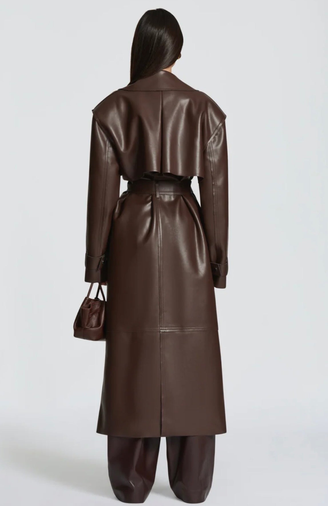 Trench Coat Maxi in Eco pelle Caratterizzato da un'ampia mantellina (gun flap), spalline strutturate, revers generosi e una cintura coordinata da annodare in vita, regala una silhouette definita e d'impatto.