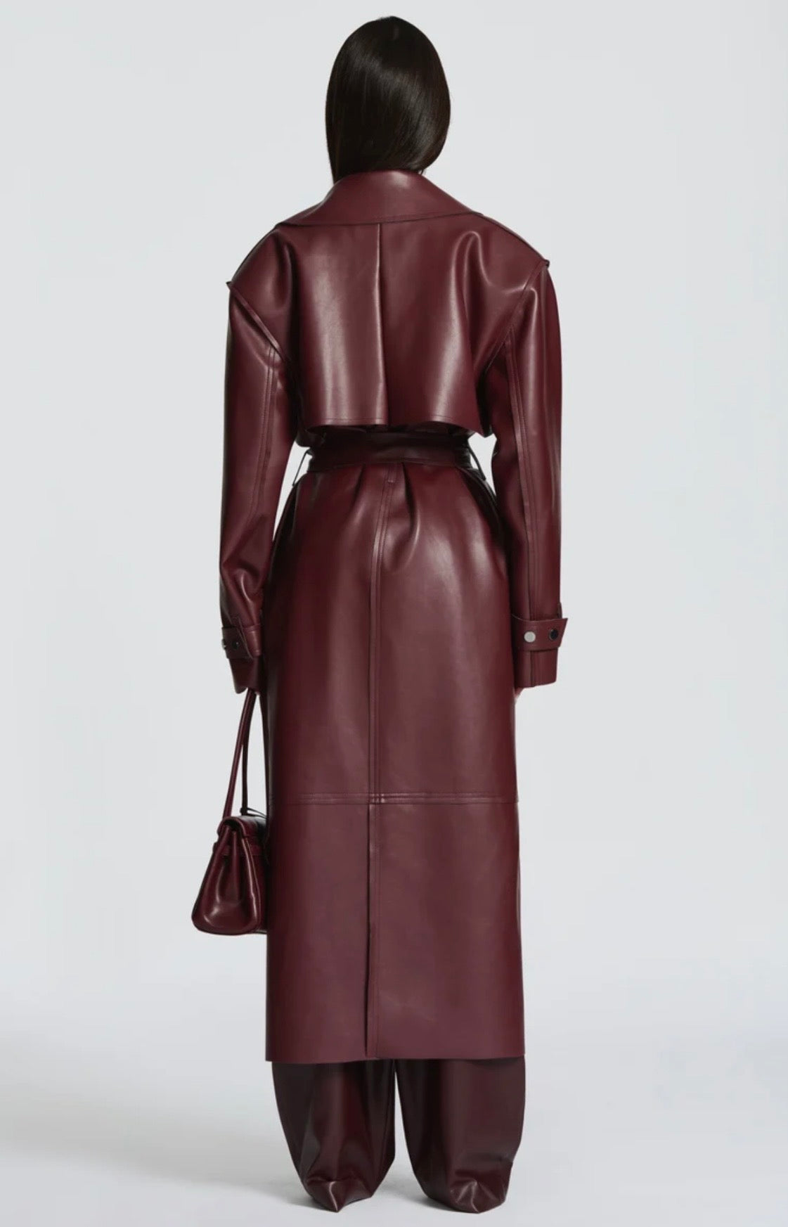 Trench Coat Maxi in Eco pelle Caratterizzato da un'ampia mantellina (gun flap), spalline strutturate, revers generosi e una cintura coordinata da annodare in vita, regala una silhouette definita e d'impatto.