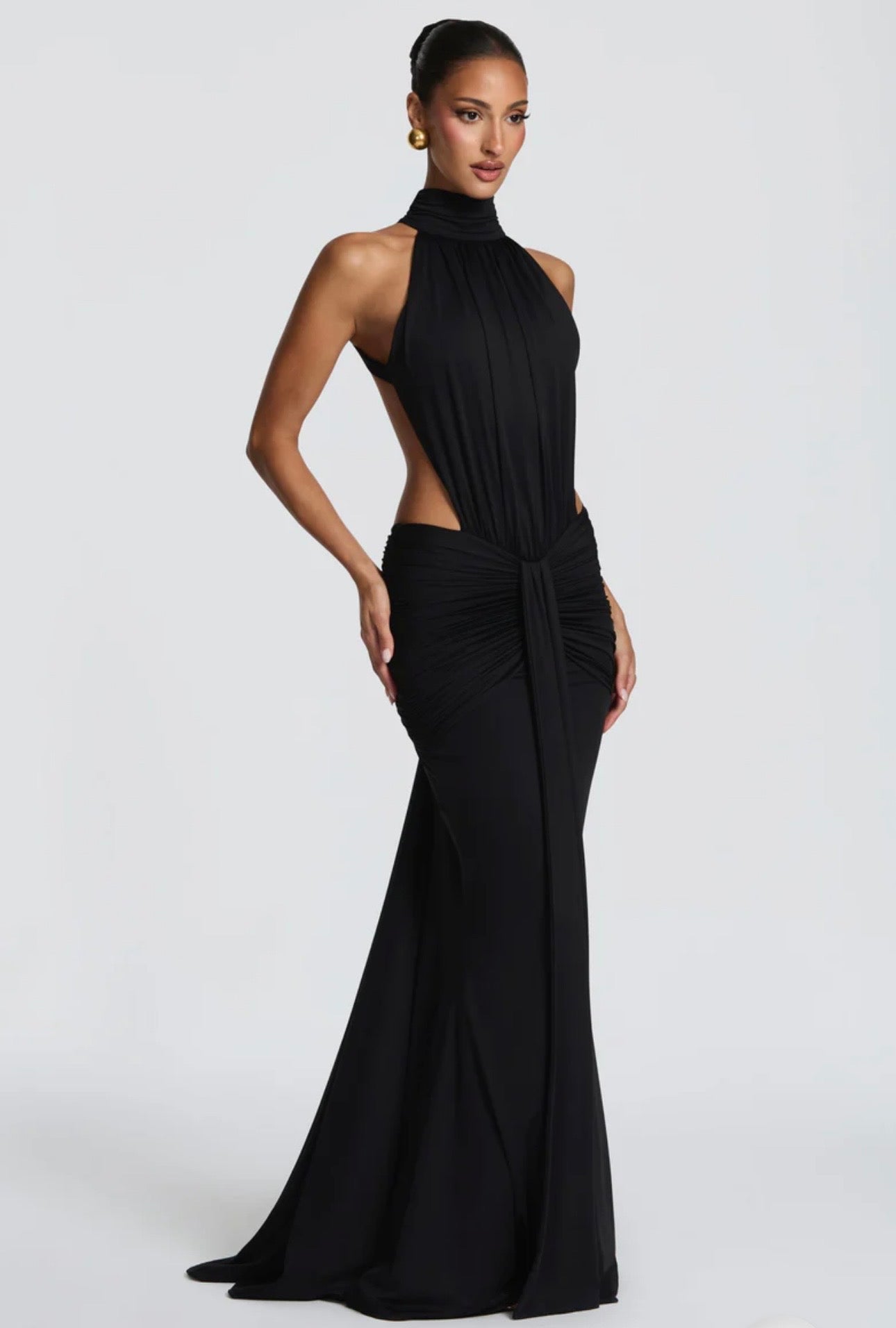 Abito Serena Caratterizzato da una silhouette a sirena che valorizza le forme, questo modello unisce un sofisticato collo alto a un audace gioco di drappeggi e intagli cut-out sui fianchi.