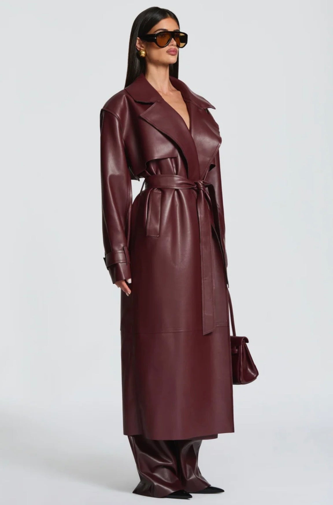 Trench Coat Maxi in Eco pelle Caratterizzato da un'ampia mantellina (gun flap), spalline strutturate, revers generosi e una cintura coordinata da annodare in vita, regala una silhouette definita e d'impatto.