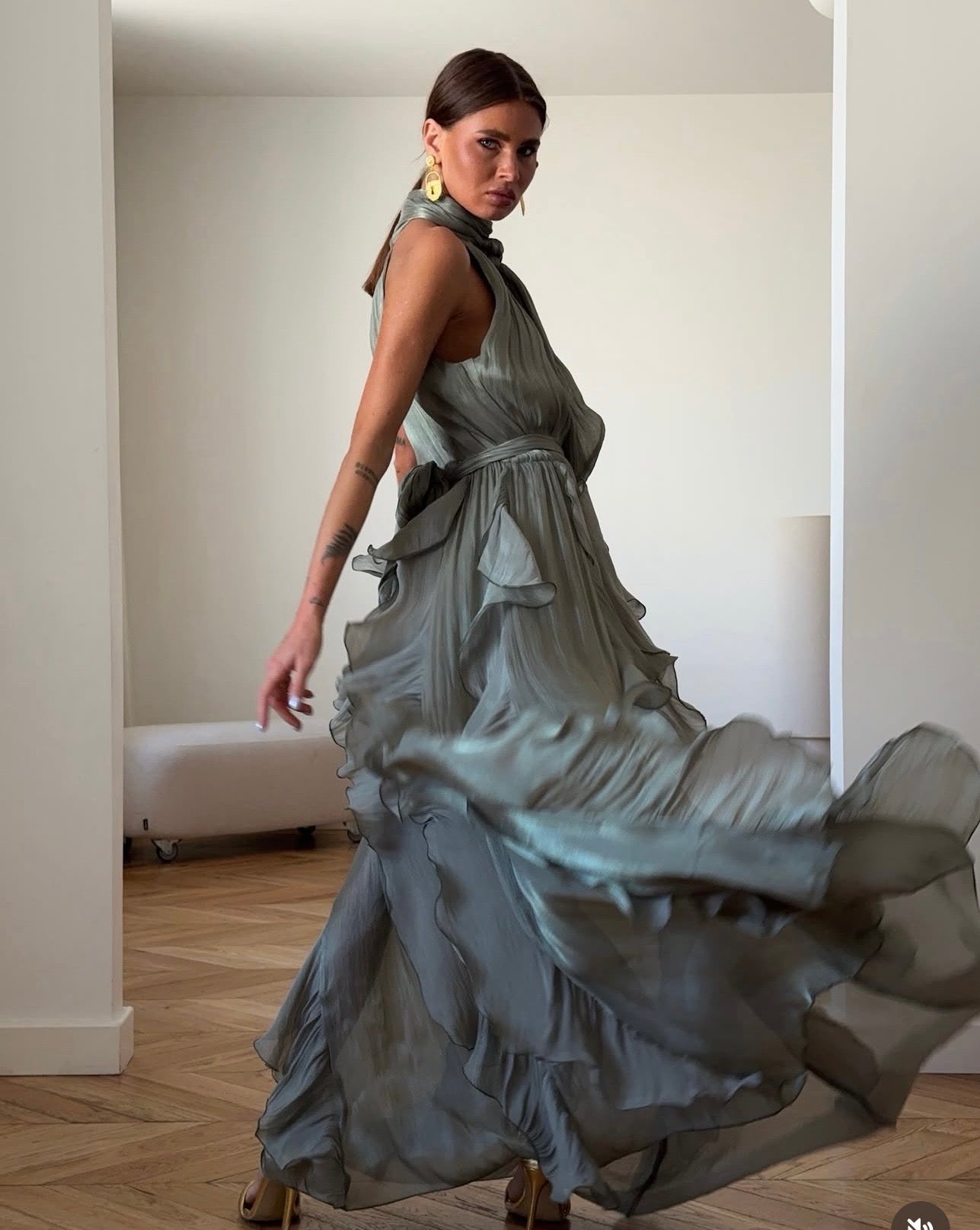 Abito Rouches maxi dress con scollo all'americana, collo con fiocco e gonna a cascata di rouches multistrato pensato per chi vuole essere al centro della scena senza sforzo. La silhouette fluida e il tessuto leggero lo rendono perfetto