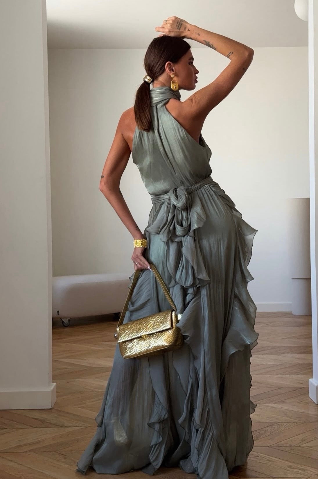 Abito Rouches maxi dress con scollo all'americana, collo con fiocco e gonna a cascata di rouches multistrato pensato per chi vuole essere al centro della scena senza sforzo. La silhouette fluida e il tessuto leggero lo rendono perfetto