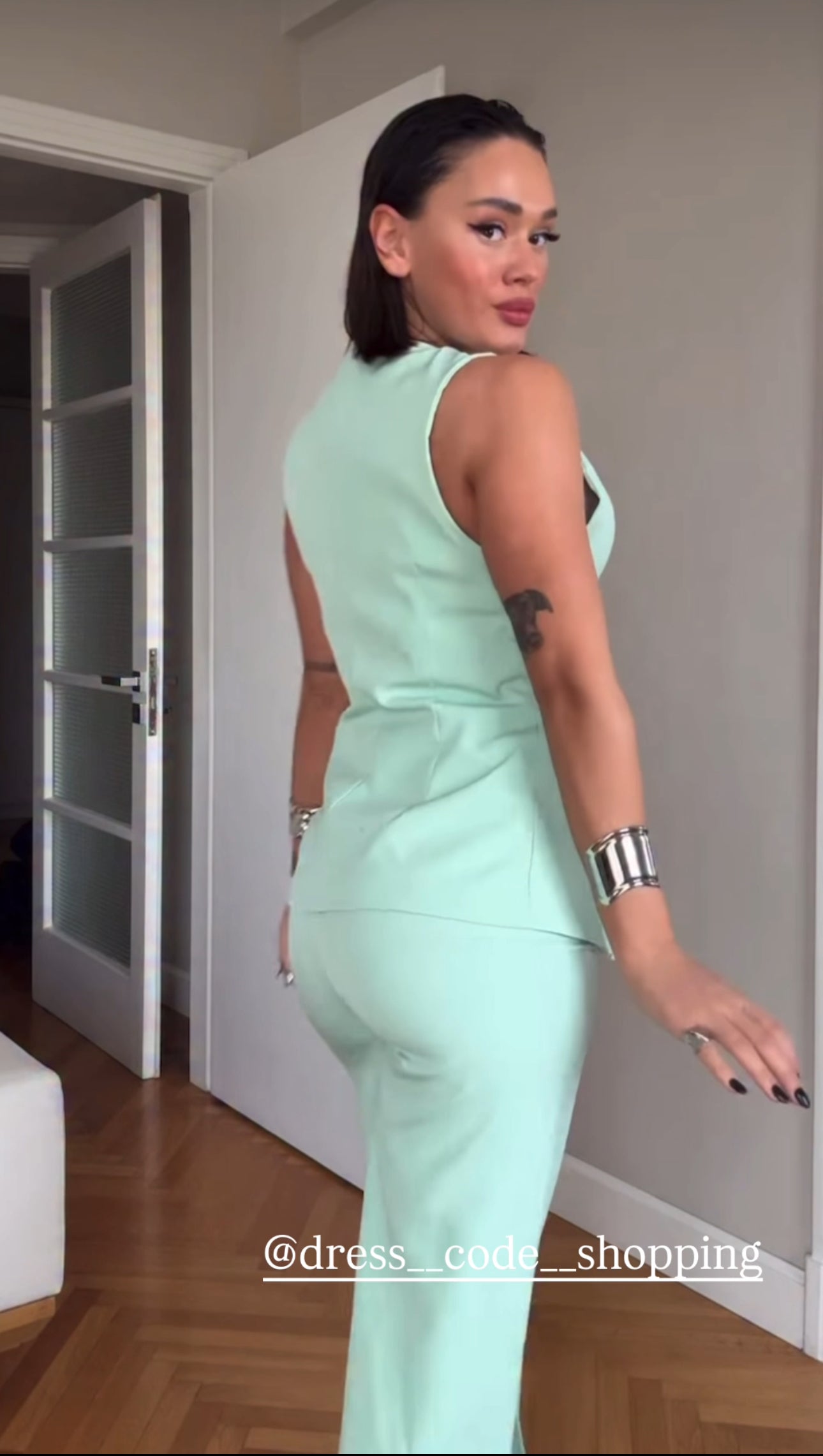 Tailleur ESTER elegante composto da un gilet smanicato e un paio di pantaloni a gamba larga  Il gilet presenta due bottoni decorativi centrali dal design gioiello. I pantaloni sono a vita alta, con una vestibilità morbida e fluida