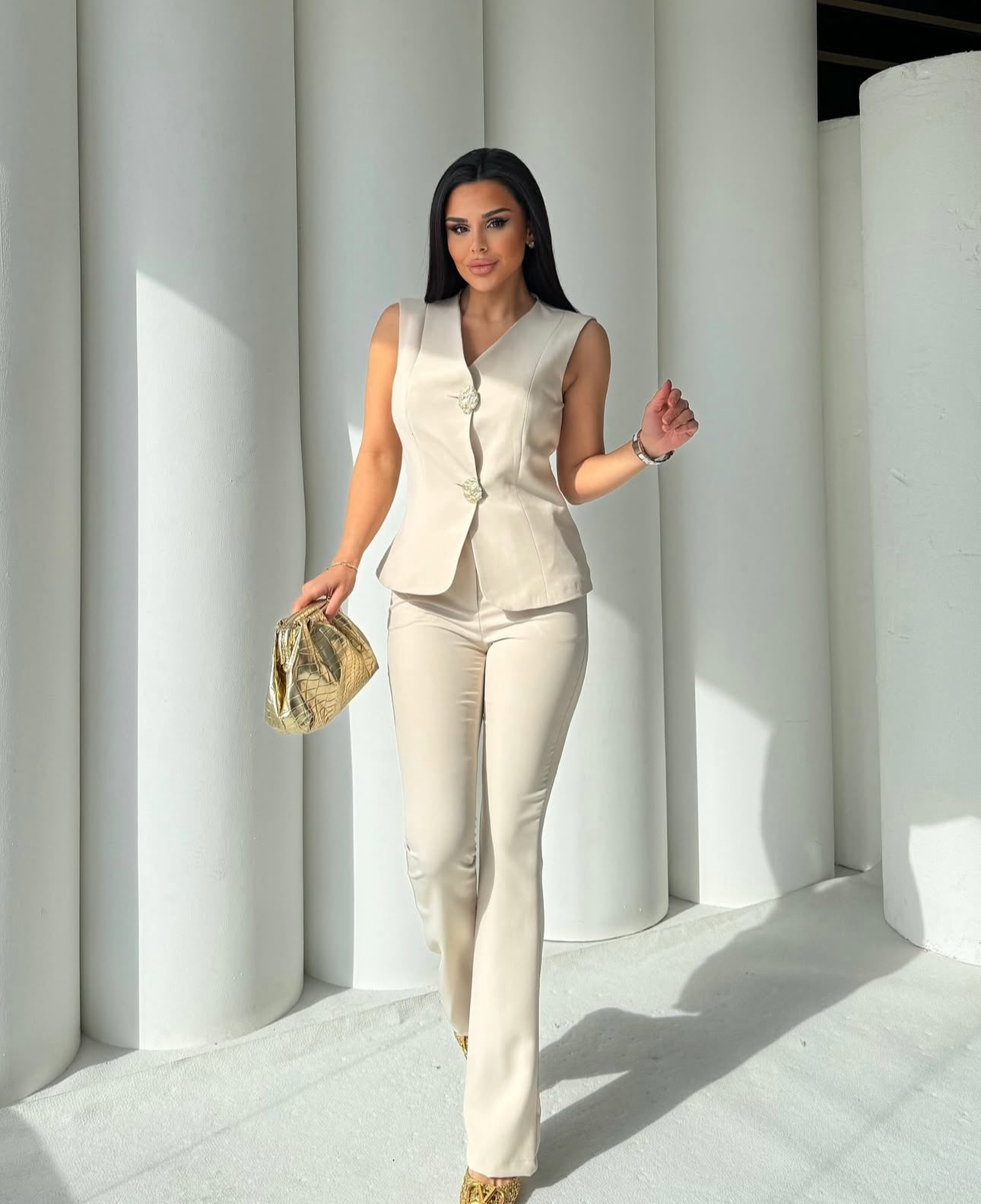 Set cord PERLA elegante composto da un gilet smanicato e un paio di pantaloni a gamba larga  Il gilet presenta due bottoni decorativi centrali dal design gioiello. I pantaloni sono a vita alta, con una vestibilità morbida e fluida